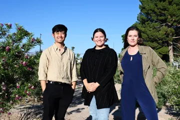 Three students pose casually for a group photo.
